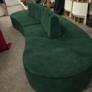 Curved low profile lounge sofa with central backrest, shown in green, orange, and black upholstery.