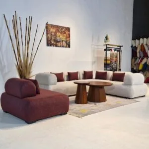 Curved bouclé modular sofa set in ivory with burgundy centre section and matching cushions in a showroom setup