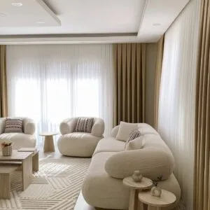 Ivory bouclé cloud sofa set with a rounded three seater and two matching accent chairs in a neutral living room.