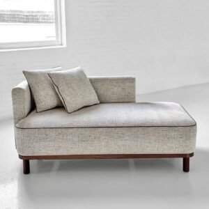 Light grey upholstered chaise lounge daybed with wood base and two back cushions, modern Airbnb living room seating