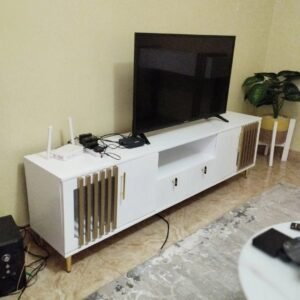 black fluted tv stand with gold handles under wall‑mounted tv in Nairobi home