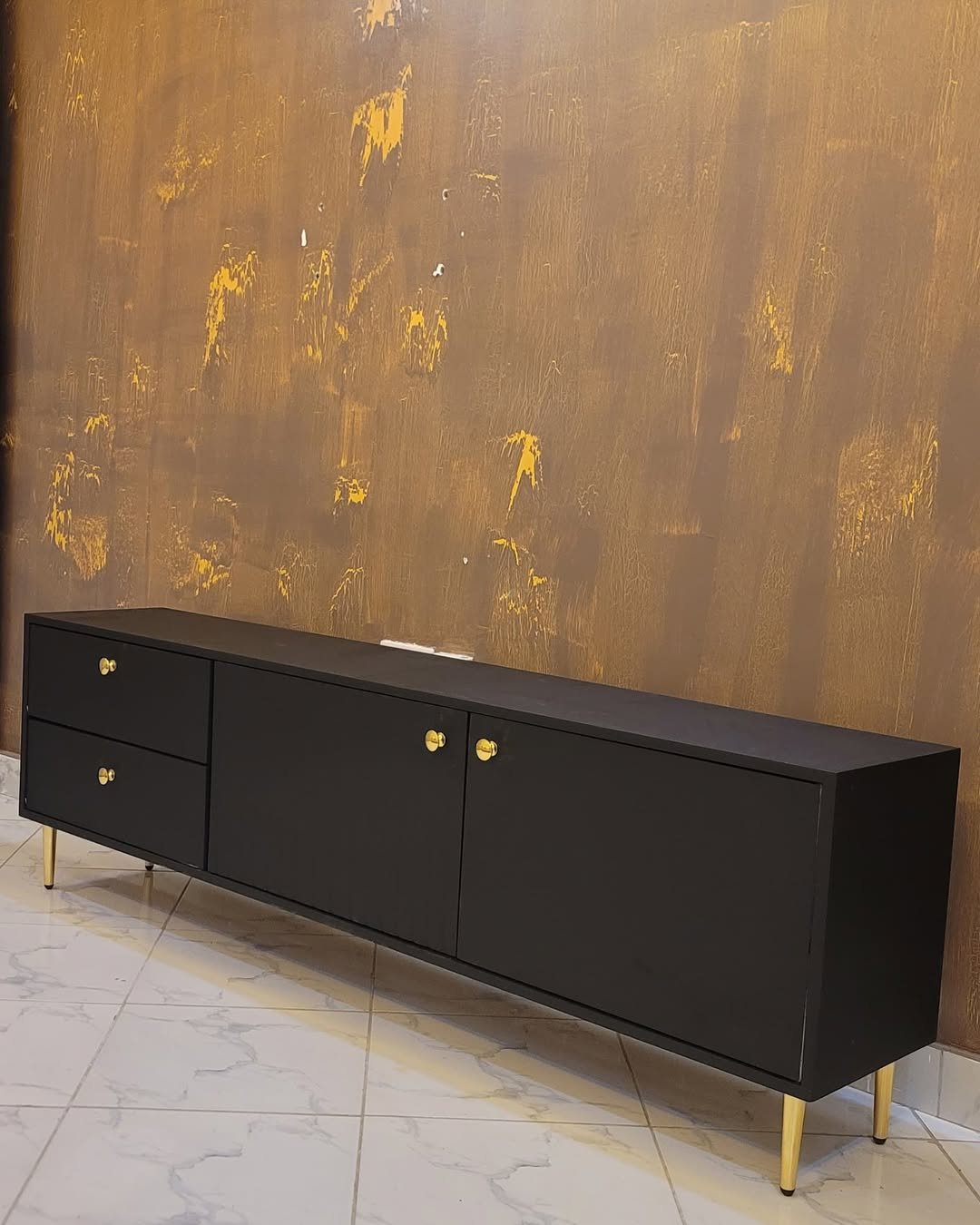 modern black TV cabinet with gold legs and storage drawers for living room furniture in Kenya