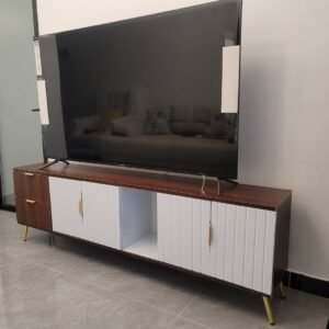 modern wooden TV cabinet with white doors and gold legs used as entertainment unit in a living room in Kenya