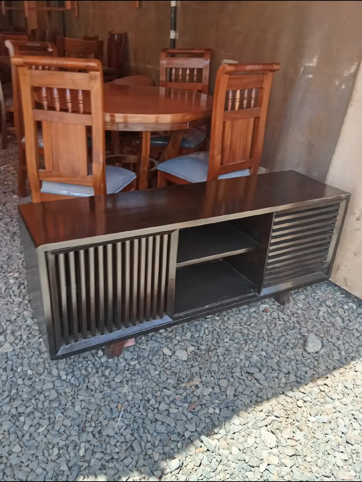 Modern black TV stand with dark top, slatted side panels, and open shelf for Kenya living rooms