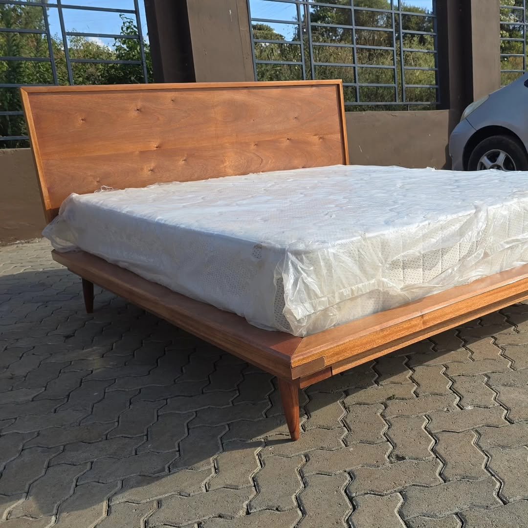 Wooden platform bed frame with wide headboard and low profile base for modern bedrooms in Kenya