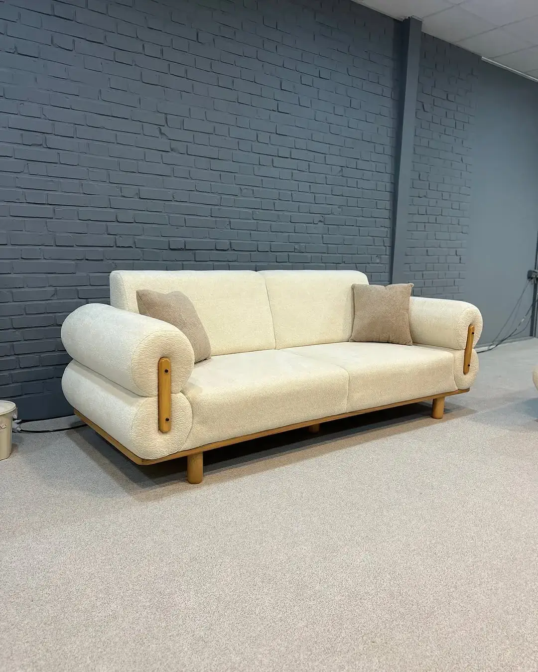 Modern cream lounge chair with wood-tone arms and rounded back for Kenya interiors