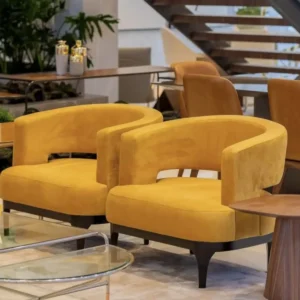 Mustard accent chair with curved back and dark tapered legs for Kenya lounge spaces
