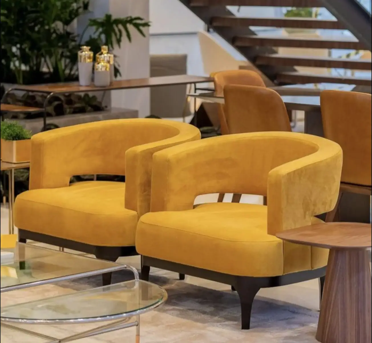 Mustard accent chair with curved back and dark tapered legs for Kenya lounge spaces