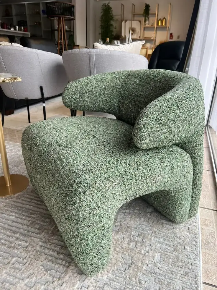 Green textured accent chair with rounded seat and wraparound back for Kenya interiors