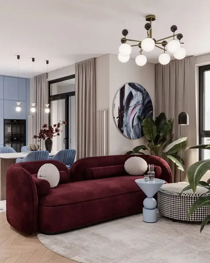 Burgundy curved sofa with rounded arms and cream cushions for modern Kenya lounge interiors