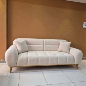Cream 3 seater sofa with rounded arms, tufted seat panels and wooden-look legs for Kenya homes