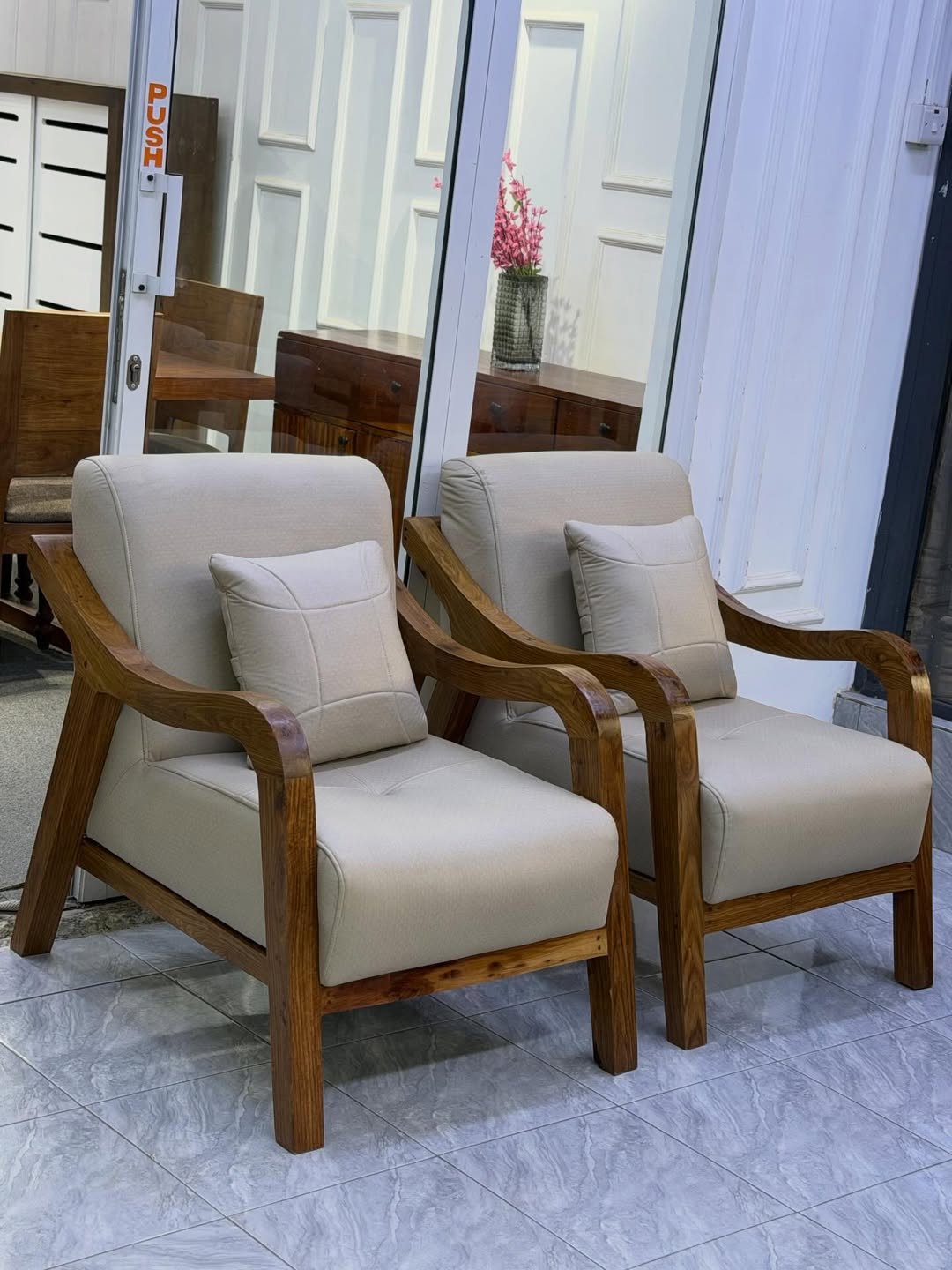 Modern 3 seater sofa Kenya style shown with beige upholstery, wooden arms and throw pillows