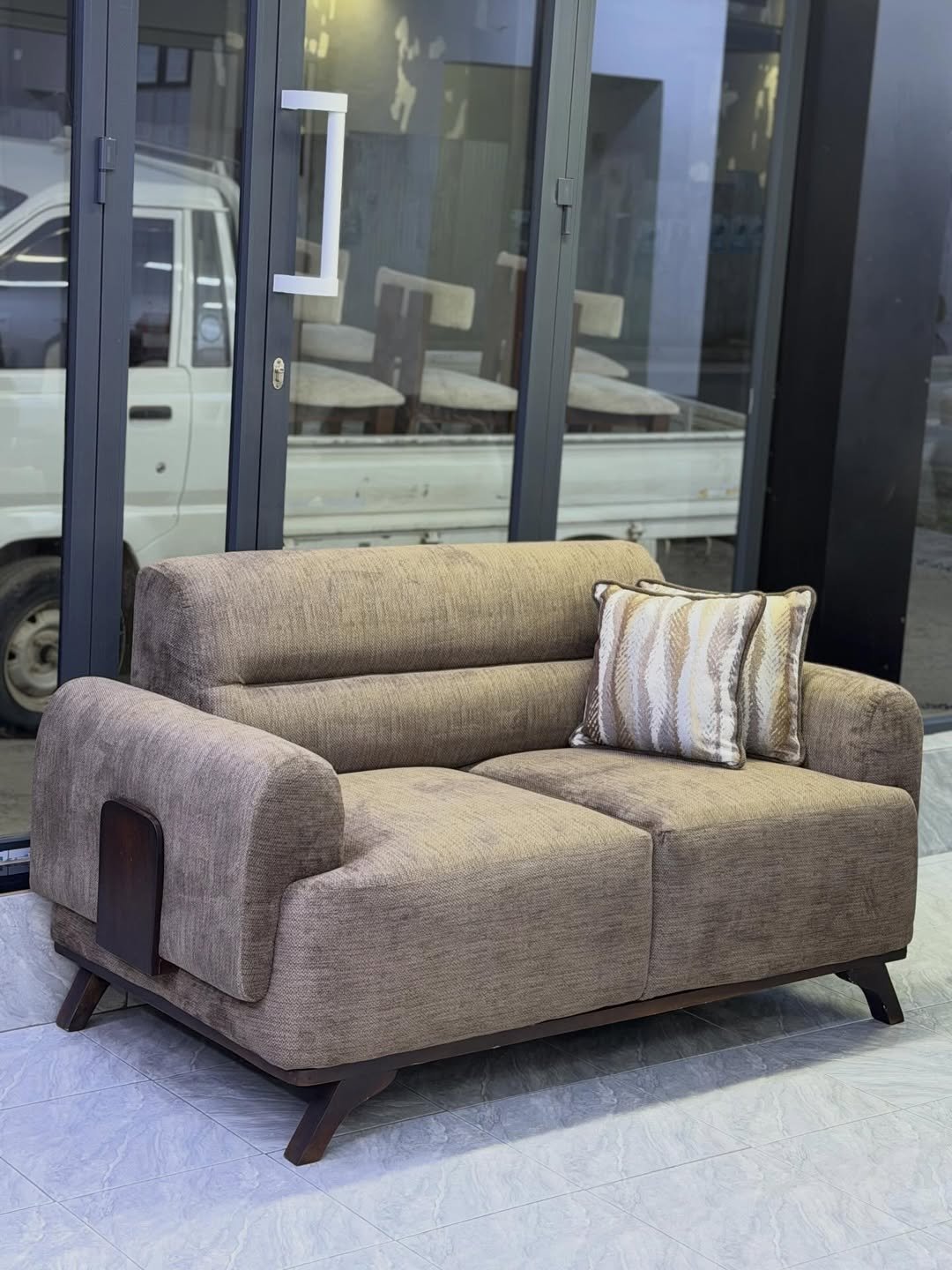 Modern 3 seater sofa Kenya with brown upholstery, raised legs and wood accent side panels
