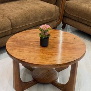 Round wooden coffee table Kenya with warm wood finish, lower shelf and curved support base