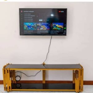 Black and gold TV stand with glass-look shelves and vertical rod frame for modern Kenya living rooms