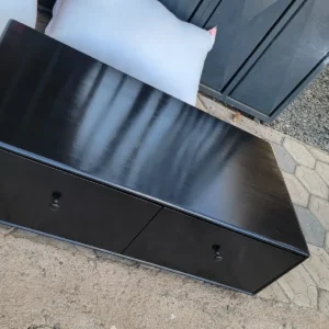 Black wood-look TV stand with open shelf and storage panels for modern living rooms in Kenya