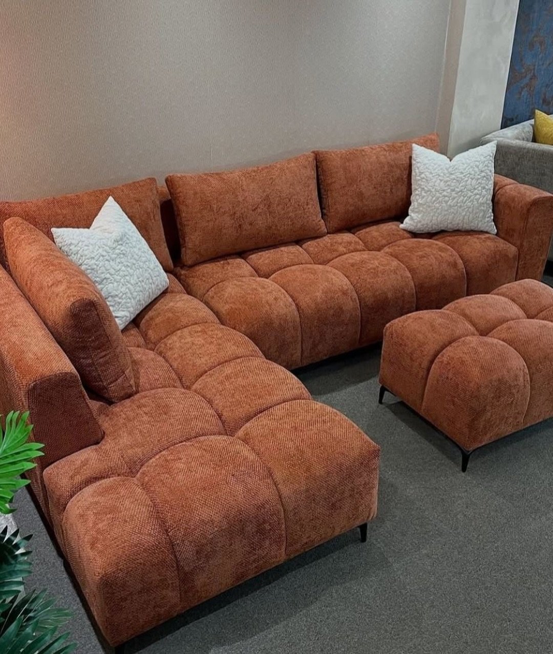 Rust orange tufted L shape sofa with matching ottoman-style piece for Kenya living rooms