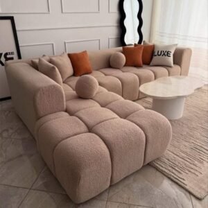 Beige tufted L shape sofa with rounded arms and chaise seating for modern Kenya living rooms