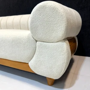 Cream curved chaise sofa with tan accents, loose cushions and wood-tone legs for Kenya lounges