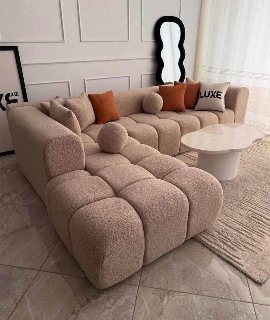 Beige tufted L shape sofa with rounded arms and chaise seating for modern Kenya living rooms