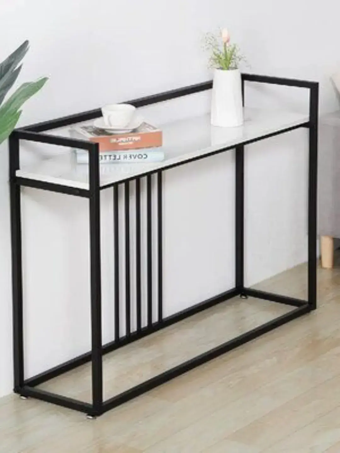 Black console table with glass-style top and vertical slat frame for Kenya entryways