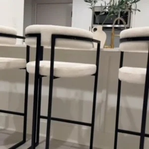 Cream bar stool with padded seat, backrest, black frame and footrest for Kenya kitchen counters