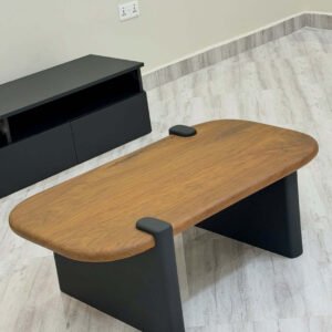 Modern coffee table with wood-look rounded top and black panel legs for Kenya living rooms