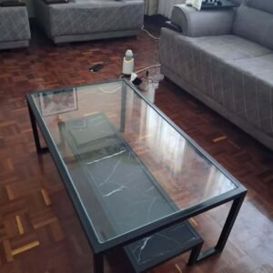 Glass coffee table with black frame and lower marble-look shelf for Kenya living rooms