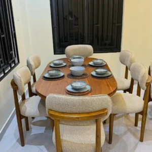 Wooden dining table set Kenya with rounded tabletop and upholstered curved chairs