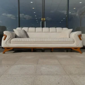 Cream sofa set Kenya with channel-tufted seat, curved arms, wood-tone accents, and matching pillows