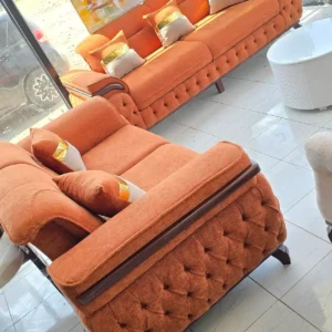 Orange sofa set Kenya with tufted sides, cushioned seats, curved arms, and dark trim accents
