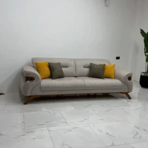 Grey sofa set Kenya with channel-tufted seat, curved arms, wood-tone accents, and throw pillows