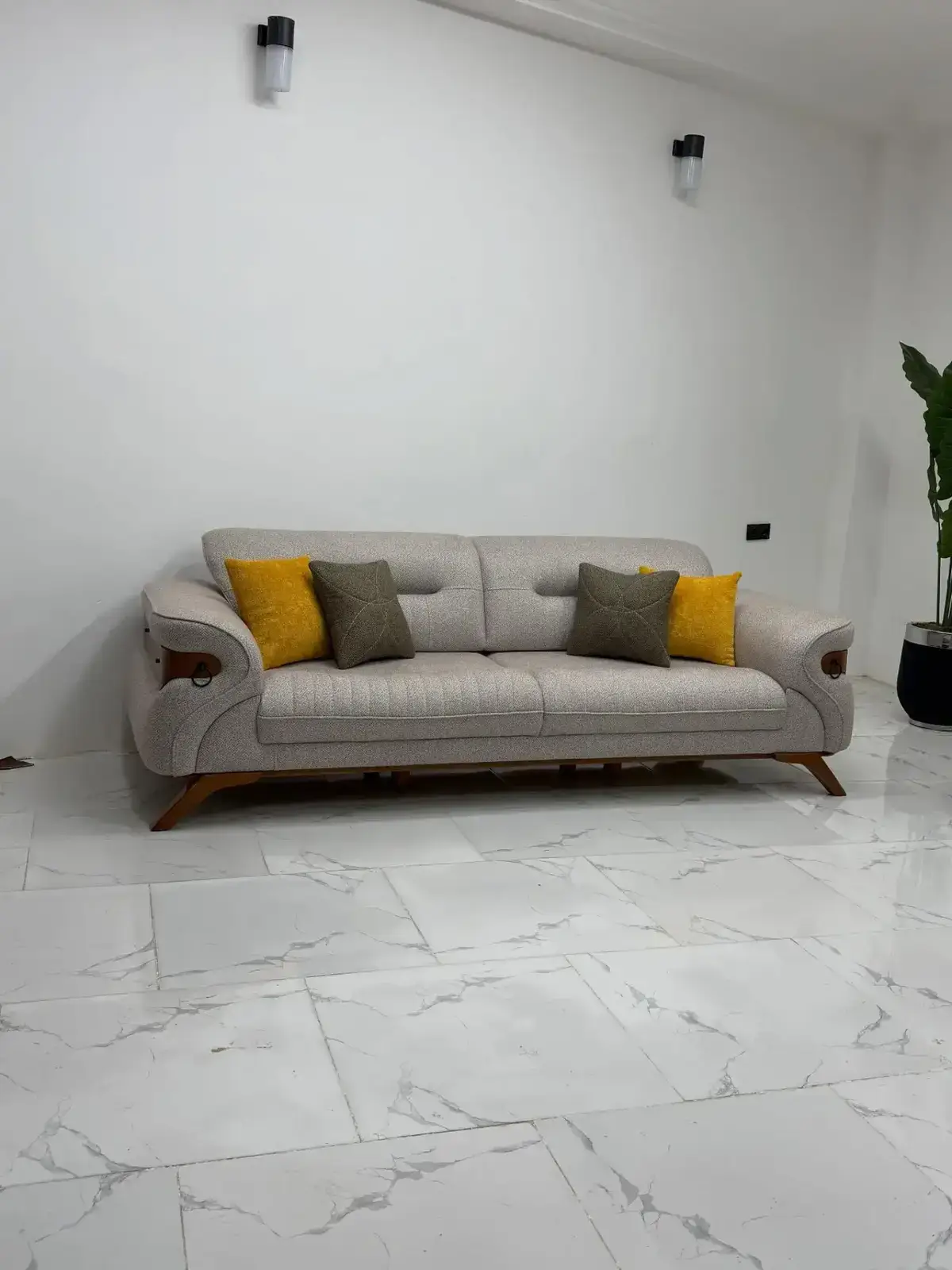 Grey sofa set Kenya with channel-tufted seat, curved arms, wood-tone accents, and throw pillows
