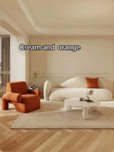 Cream and orange — minimal curved sofa with bold orange accent chair on herringbone floor