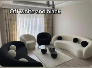 Off-white and black living room — sculptural bubble chairs, glass coffee table, monochrome palette