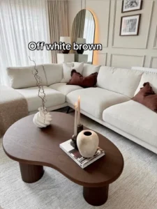 Off-white and brown living room — large modular sectional, organic-shaped wooden coffee table