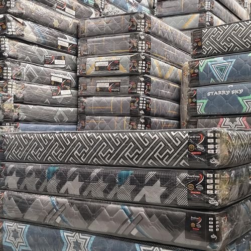 Fortress Premium Fiber Mattress Kenya — Orthopedic HD shown in warehouse-style mattress storage – firm mattress