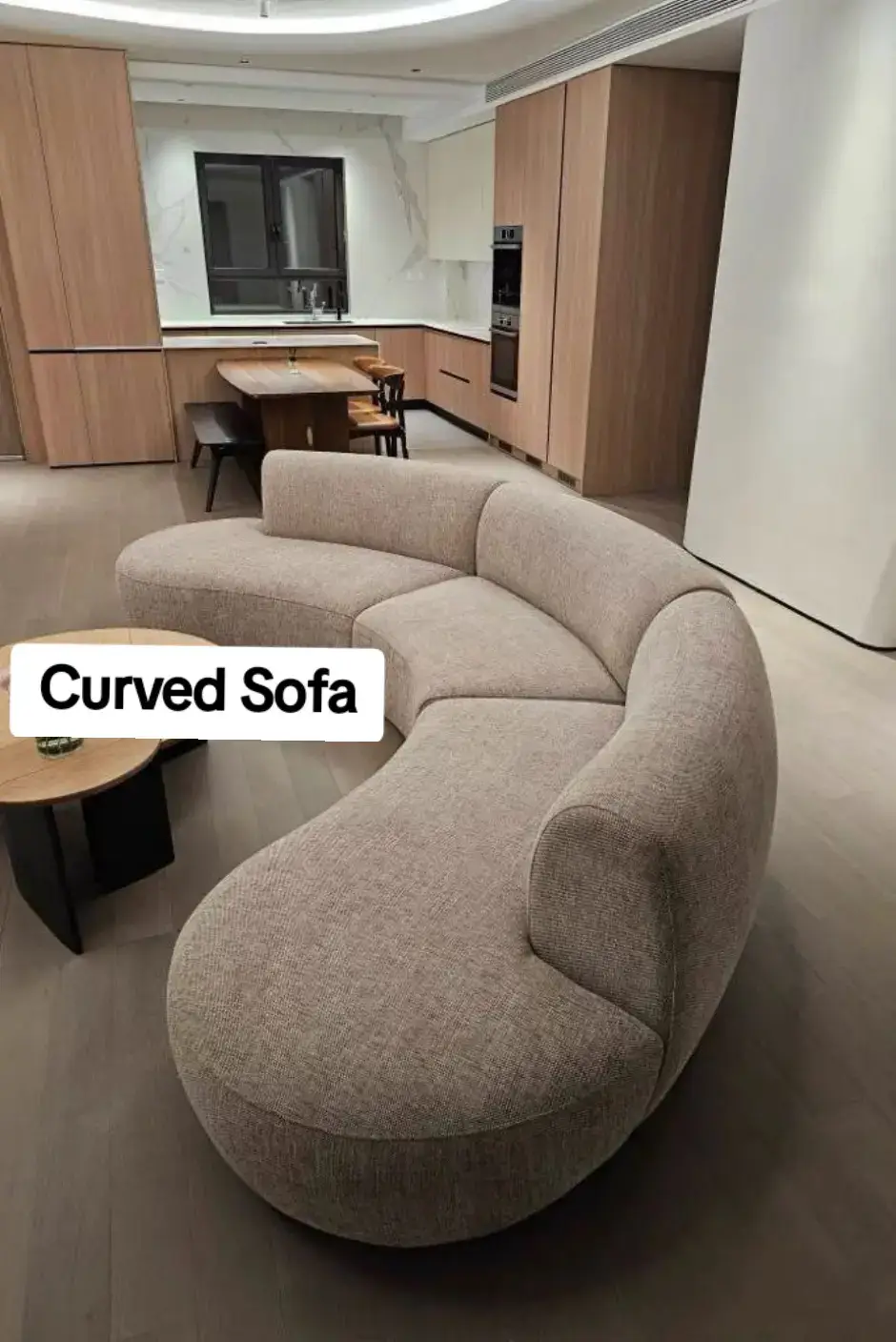 Beige curved kidney-shaped sofa in an open-plan kitchen-living Nairobi apartment — contemporary design