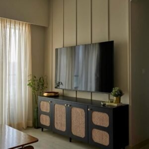 Black cane-look 4 door TV cabinet Kenya with six woven panels, gold-tone knobs, short legs and a wide media-console top.