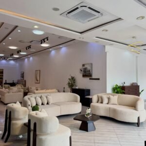 Cream curved 3 seater sofa Kenya with textured upholstery, wraparound back, rounded arms and dark wood-tone front legs.
