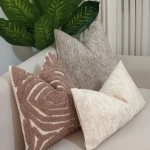 Five-piece mushroom, grey and cream throw pillow set with raised abstract tufting styled on a neutral sofa in Nairobi