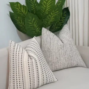 Four ivory geometric and grey ribbed throw pillows arranged on a neutral sofa in Nairobi