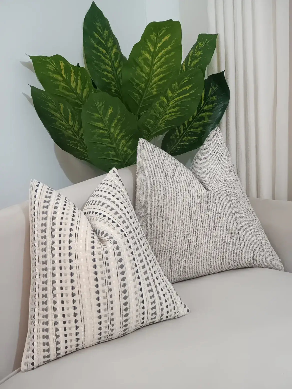 Four ivory geometric and grey ribbed throw pillows arranged on a neutral sofa in Nairobi