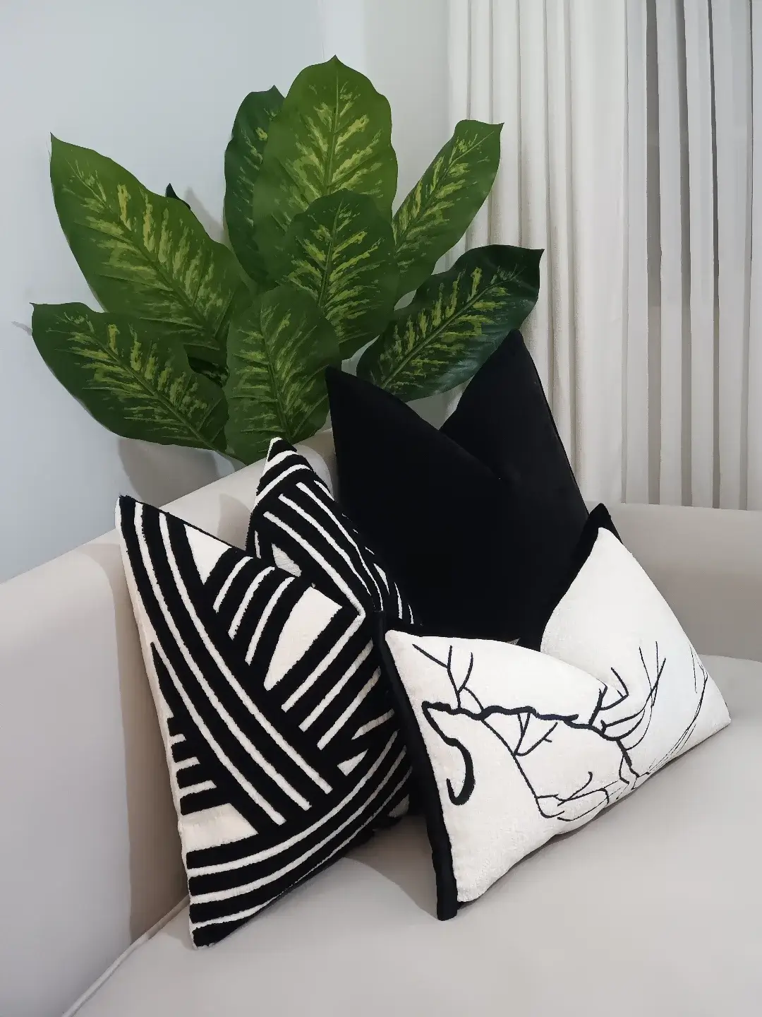 Four-piece black and white textured throw pillow set with stripes, abstract blocks, solid black and deer line art in Kenya