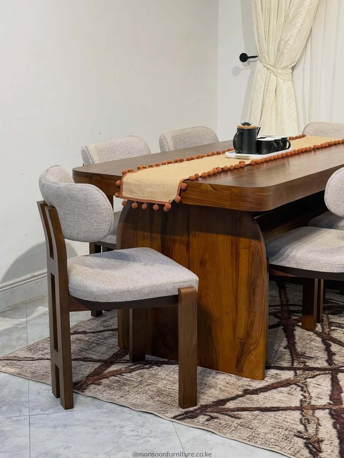 Walnut modern 6 seater dining set with sculptural pedestal table and upholstered grey chairs in Kenya