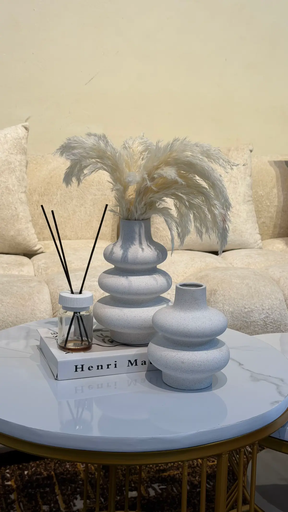 Round wooden coffee table styled with a single central arrangement