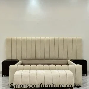Cream vertical-channel bed with bench Kenya, tall upholstered headboard, matching foot panel and two dark bedside units.