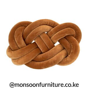 Deep teal plush braided flat-knot throw pillow on a woven rattan table beside a light sofa in Kenya