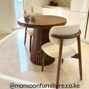 Dark wood round 2 seater dining set Kenya with a slatted pedestal table and two cream upholstered curved-back chairs.