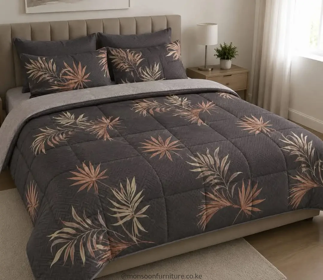 quilted duvet with cream and muted rust leaf motifs and a light-grey reverse on a bed.